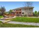 A sprawling backyard with an outdoor fire pit, lush lawn, and a patio space at 7355 Nile St, Arvada, CO 80007
