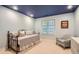Light-filled bedroom with a cozy daybed, chair, and a large window offering natural light at 7355 Nile St, Arvada, CO 80007