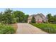 Charming two-story home with lush landscaping, mature trees, and a long driveway on a sunny day at 7355 Nile St, Arvada, CO 80007
