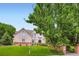 Two-story home with a well-manicured lawn, mature trees, garden, and brick mailbox at 7355 Nile St, Arvada, CO 80007