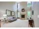 Bright living room boasts high ceilings, neutral walls, a stone fireplace, and many windows at 7355 Nile St, Arvada, CO 80007