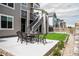 Fenced backyard with a patio with outdoor dining set, grass, and side staircase for easy access at 3421 E 143Rd Dr, Thornton, CO 80602