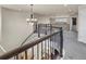 Bright foyer with a wrought iron banister and contemporary chandelier at 3421 E 143Rd Dr, Thornton, CO 80602
