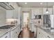 Bright kitchen with white cabinets, granite countertops, stainless steel appliances, and dark hardwood floors at 3421 E 143Rd Dr, Thornton, CO 80602