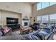 Bright living room with high ceilings, large windows, modern fireplace, and leather furniture at 3421 E 143Rd Dr, Thornton, CO 80602