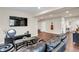 Open living room with dark wood floors, entertainment center and dark black sofa at 3421 E 143Rd Dr, Thornton, CO 80602