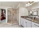 Spa-like shower with glass enclosure, tiled walls, dual shower heads, and a granite vanity in the spacious bathroom at 3421 E 143Rd Dr, Thornton, CO 80602