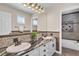Bathroom features a double sink vanity with granite counters and a bathtub shower with tiled walls at 693 Syracuse St, Denver, CO 80230