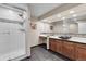 Bathroom includes shower and vanity with vessel sink, cabinetry and large mirror at 693 Syracuse St, Denver, CO 80230