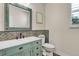 A charming powder room showcases a decorative mirror, decorative sink and toilet at 693 Syracuse St, Denver, CO 80230