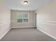This bedroom has gray carpet and a window with white shutters and white trim at 693 Syracuse St, Denver, CO 80230