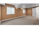 Neutral colored bedroom with carpet, two windows, and a paneled door at 693 Syracuse St, Denver, CO 80230