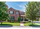 Beautiful brick home with mature trees, landscaped yard, and inviting front porch at 693 Syracuse St, Denver, CO 80230