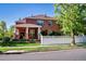 Two story brick home with a covered front porch and well manicured yard at 693 Syracuse St, Denver, CO 80230