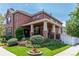 Charming brick home with a welcoming front porch and well-manicured landscaping at 693 Syracuse St, Denver, CO 80230
