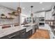 Bright kitchen features stainless steel appliances, a large island, granite countertops, and stylish pendant lighting at 693 Syracuse St, Denver, CO 80230