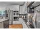 A kitchen with stainless steel appliances, white cabinetry, subway tile backsplash, and modern countertops at 693 Syracuse St, Denver, CO 80230