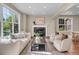 Bright living room featuring large windows, fireplace, and plush seating at 693 Syracuse St, Denver, CO 80230
