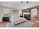 Elegant main bedroom with fireplace, wood accent wall, and plantation shutters offers a relaxing retreat at 693 Syracuse St, Denver, CO 80230