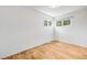Bright bedroom featuring hardwood floors and natural light from two windows at 107 S Windsor Dr, Denver, CO 80219