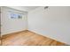 Bedroom features hardwood floors and a single window for natural light at 107 S Windsor Dr, Denver, CO 80219