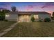 Charming single-story home with a well-manicured lawn at sunset with a classic covered front porch and large windows at 107 S Windsor Dr, Denver, CO 80219
