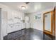 Kitchen with white cabinets and appliances plus a stacked washer dryer at 107 S Windsor Dr, Denver, CO 80219