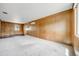 Spacious living room with wood paneling, carpet and natural light at 107 S Windsor Dr, Denver, CO 80219