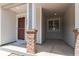 Inviting covered front porch with brick columns and a sheltered entry at 19043 E 58Th Ave, Denver, CO 80249