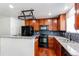 Modern kitchen featuring cherry cabinets, granite countertops, and black appliances at 19043 E 58Th Ave, Denver, CO 80249