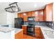 Well-equipped kitchen showcasing cherry cabinets, granite countertops, and pot rack at 19043 E 58Th Ave, Denver, CO 80249