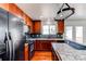 Cozy kitchen featuring cherry cabinets, granite countertops, and modern appliances at 19043 E 58Th Ave, Denver, CO 80249