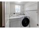Laundry room with a washer, a dryer, a window, shelving, and white walls at 19043 E 58Th Ave, Denver, CO 80249
