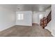 Bright living room with neutral carpet, white walls, and a view of the entryway and stairs at 19043 E 58Th Ave, Denver, CO 80249