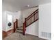 Carpeted staircase with wood railings, leading to the upper level, next to the laundry room at 19043 E 58Th Ave, Denver, CO 80249