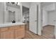 Updated bathroom with wood-like flooring, a large mirror, and bright lighting fixtures at 9232 Bauer Ct, Lone Tree, CO 80124