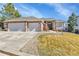 Charming brick home with a well-manicured lawn, three-car garage, and inviting entryway at 9232 Bauer Ct, Lone Tree, CO 80124