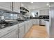 Elegant kitchen with granite countertops, stainless steel appliances, and light wood floors at 9232 Bauer Ct, Lone Tree, CO 80124
