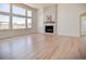 Bright living room boasts large windows, a stone fireplace, and hardwood floors at 9232 Bauer Ct, Lone Tree, CO 80124
