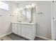 This bathroom features a double vanity and modern lighting fixtures at 457 Interlocken Blvd # 106, Broomfield, CO 80021