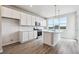 Open concept kitchen featuring gray wood flooring, large windows and stainless steel appliances at 457 Interlocken Blvd # 106, Broomfield, CO 80021