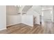 An open concept living room shows a stairwell and grey wood flooring at 457 Interlocken Blvd # 106, Broomfield, CO 80021