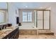 Bright bathroom with a soaking tub, glass enclosed shower, granite counters, and neutral tile flooring at 9458 S Hackberry Ln, Highlands Ranch, CO 80129