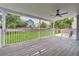 Charming covered deck with ceiling fan, white railings, and a view of the fenced backyard at 9458 S Hackberry Ln, Highlands Ranch, CO 80129