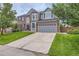 Charming two-story home with a well-kept lawn and a long driveway leading to an attached two-car garage at 9458 S Hackberry Ln, Highlands Ranch, CO 80129
