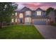 Beautiful two-story home with brick and siding, a well-manicured lawn, and an attached two-car garage at 9458 S Hackberry Ln, Highlands Ranch, CO 80129