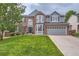 Attractive two-story home with brick accents, a manicured lawn, and an attached two-car garage at 9458 S Hackberry Ln, Highlands Ranch, CO 80129