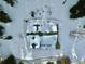 Aerial view of a snow covered cabin with green roof surrounded by sparse trees and snow at 812 High Point Dr, Breckenridge, CO 80424