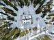 Aerial view of a snow covered cabin with green roof surrounded by a forest of trees at 812 High Point Dr, Breckenridge, CO 80424