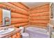 Cozy log cabin bathroom with a soaking tub, tiled walls, and a vanity with sink at 812 High Point Dr, Breckenridge, CO 80424
